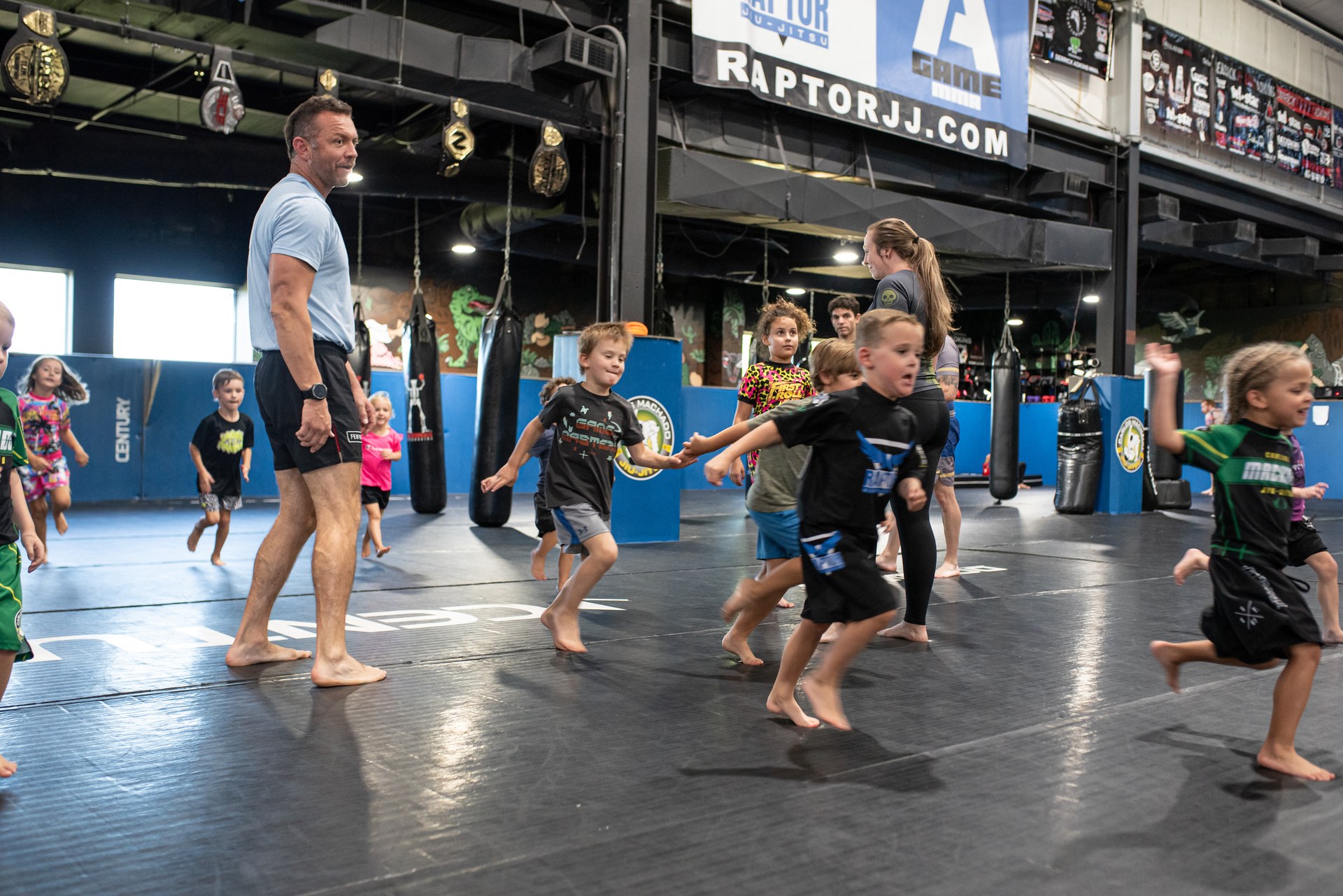 Kids running warm-ups under the Raptor JJ sign